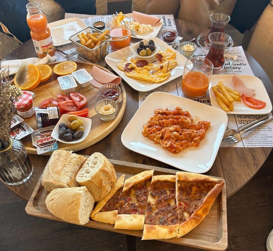 Planche brunch généreuse avec pain, olives, œufs et jus frais